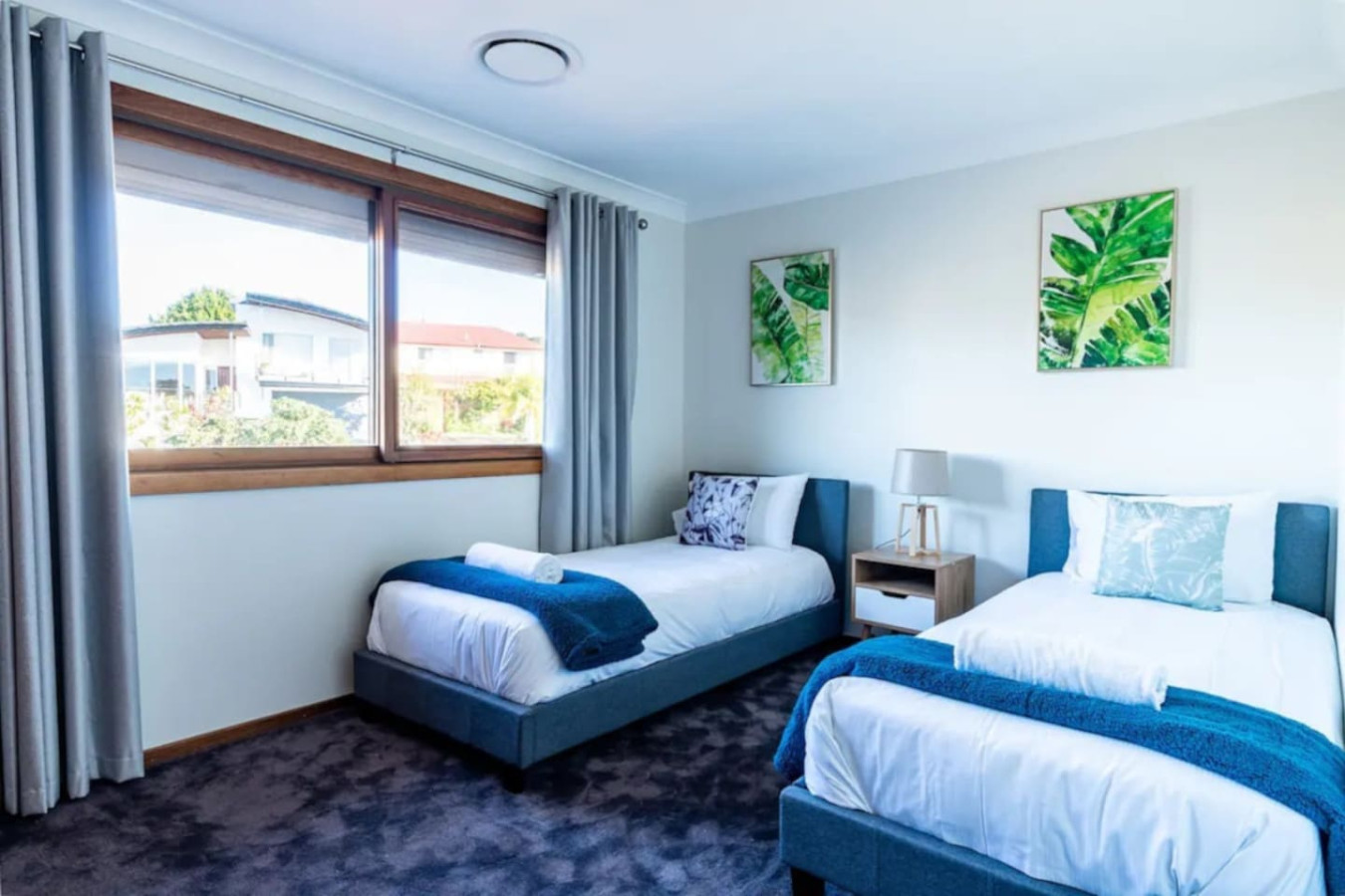 Sunlight streams into the bedroom through its large windows.