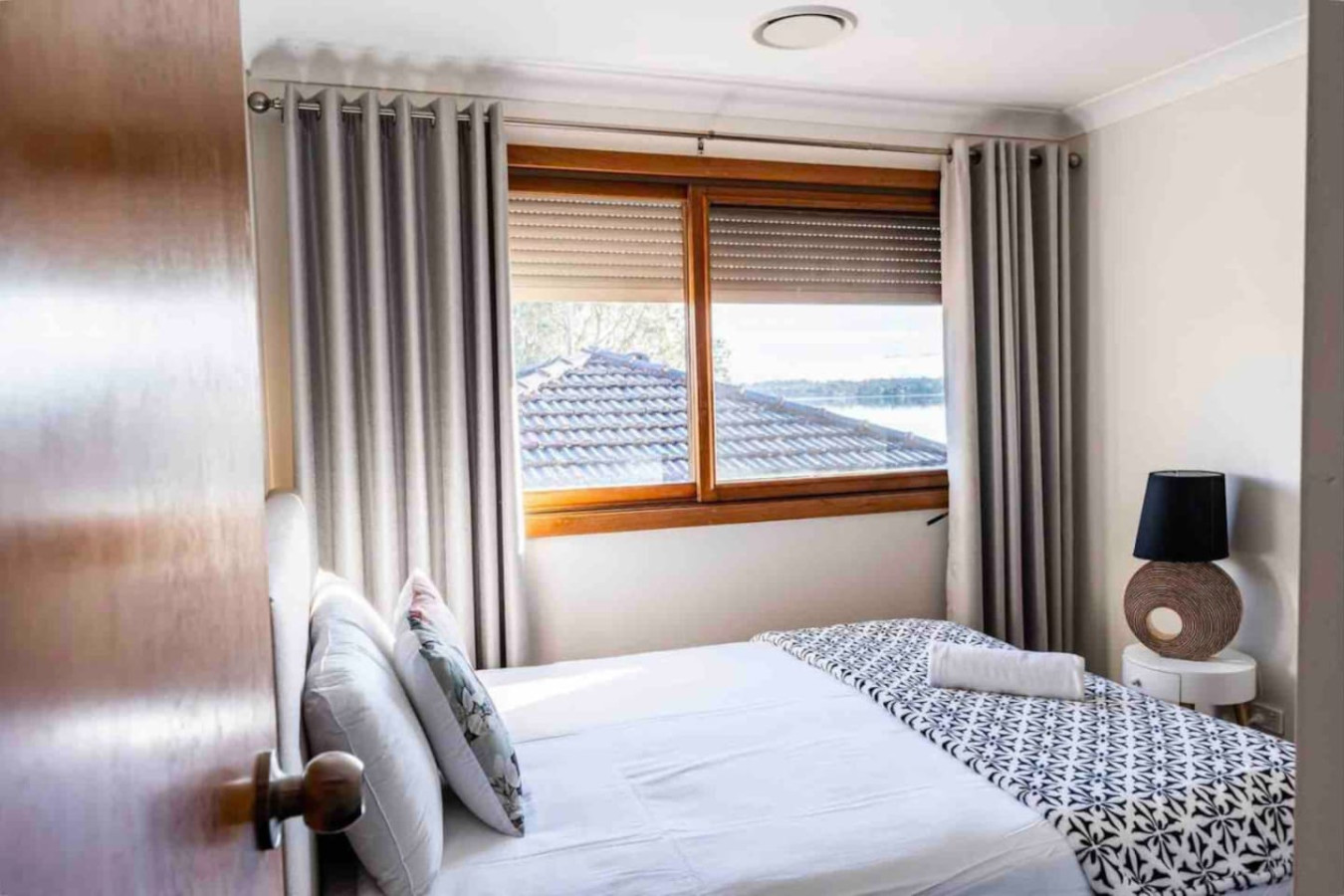 Natural light fills the bedroom through its windows.