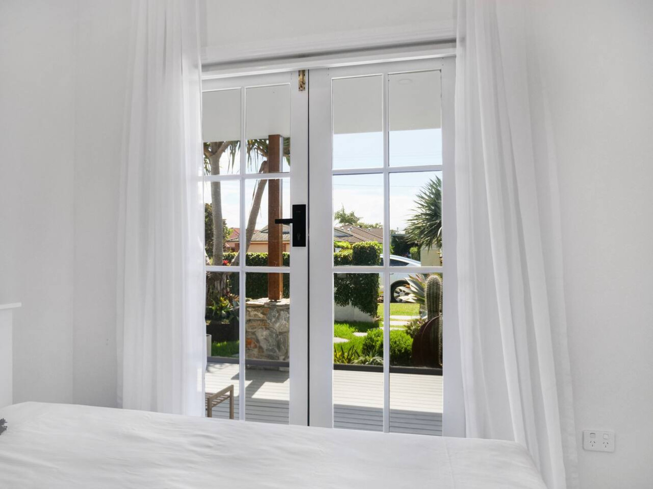 Cozy bed nestled by a charming window, offering serene views and natural light for a peaceful stay.