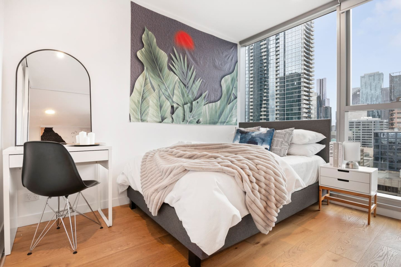Elegant bedroom with a queen-sized bed and stunning city views.