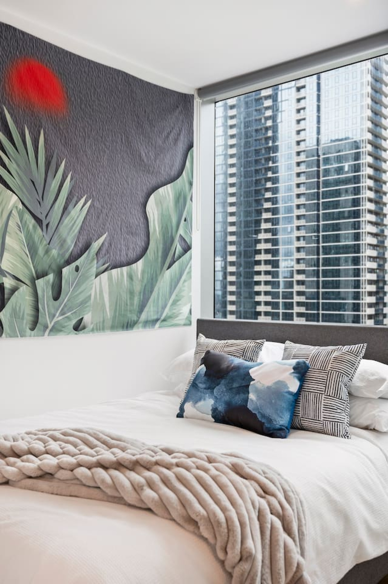 Elegant bedroom with a queen-sized bed and stunning city views.