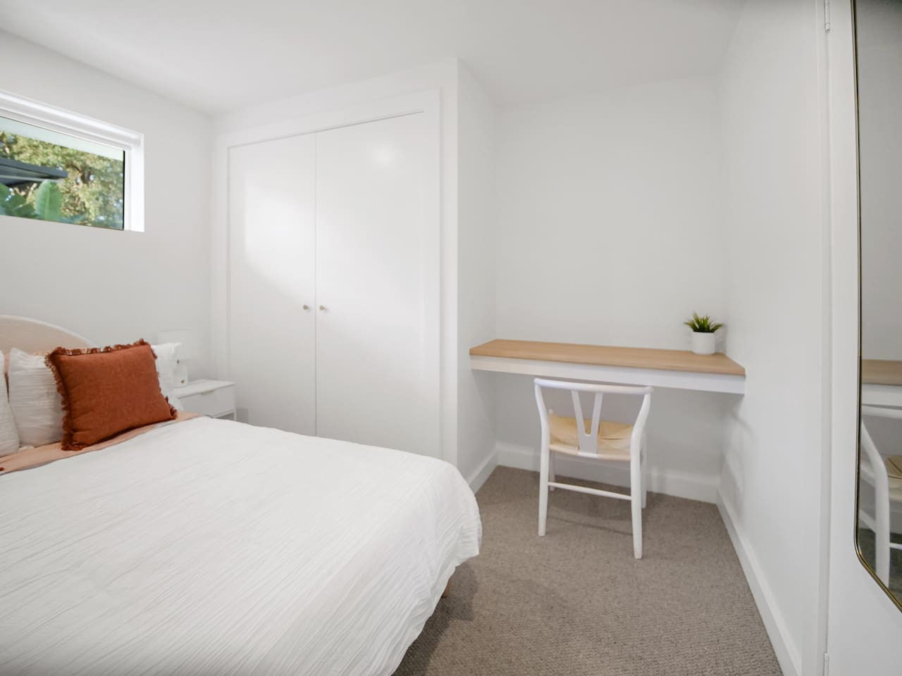 Efficiently designed bedroom with wardrobe and workspace.