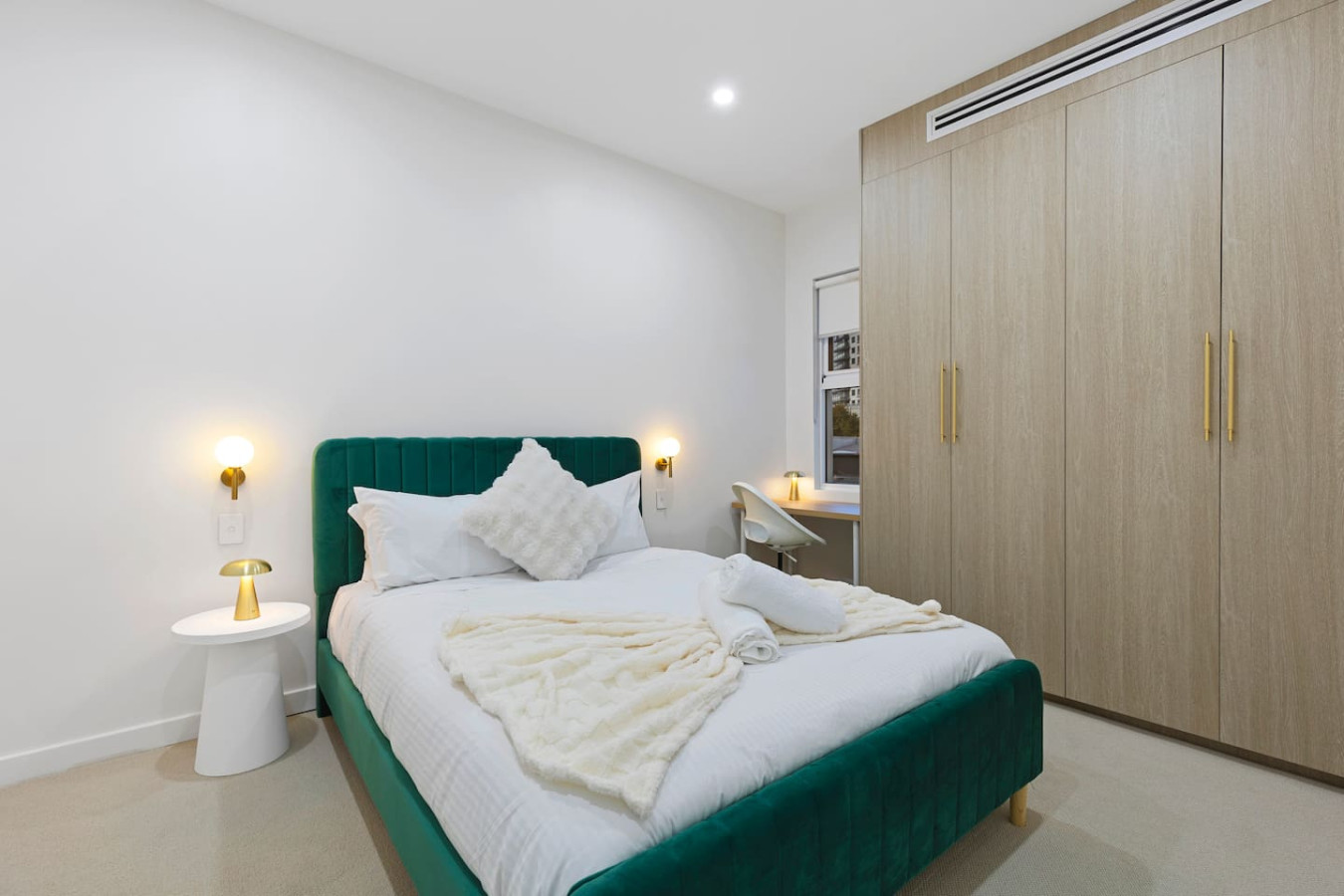 Modern queen size bed with a cozy bed, warm lighting, and a stylish workspace for a relaxing stay. By Superhostly
