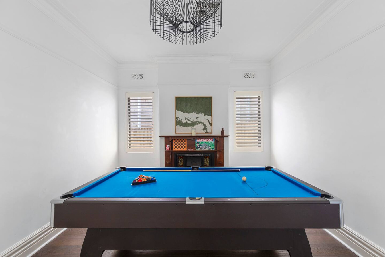 A stylish and inviting game room, complete with a vibrant pool table and classic board games—perfect for entertainment and relaxation! By Superhostly
