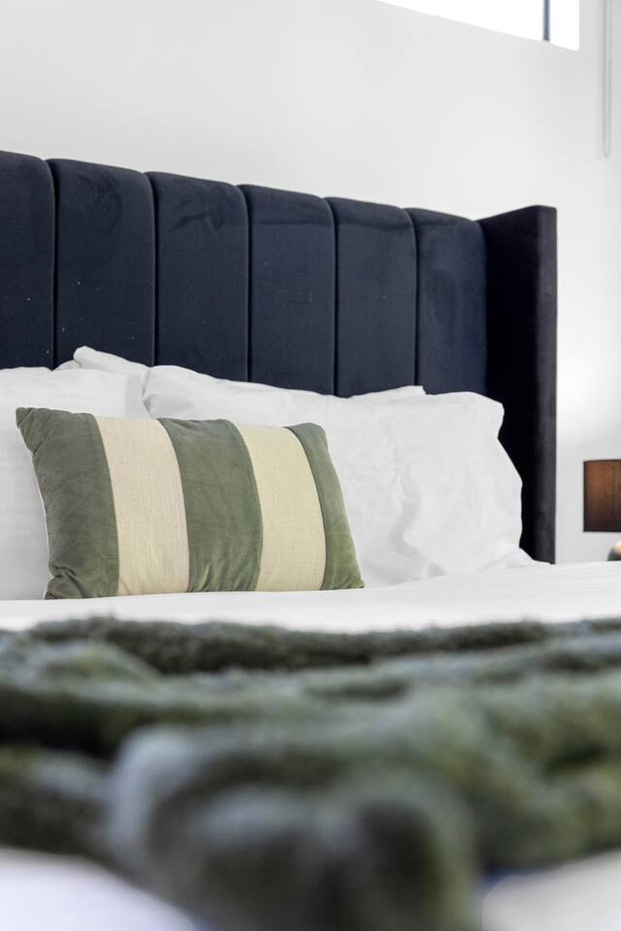 A spacious and modern king bedroom with a luxurious king-size bed, large windows allowing natural light to flow in, and a stunning view of lush greenery. By Superhostly