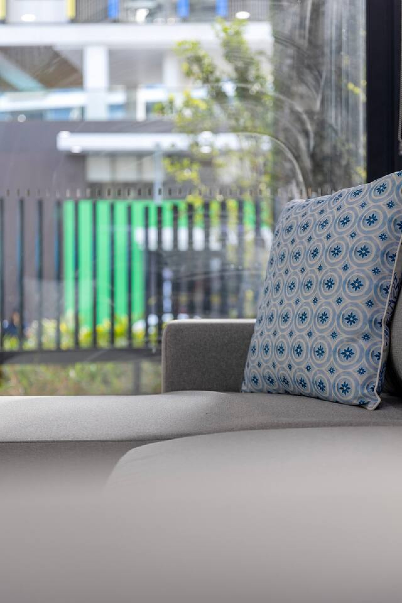 Unwind in style at this modern, sunlit retreat featuring a cozy sofa and chic patterned pillow—perfect for relaxing after a day of city exploring. By Superhostly