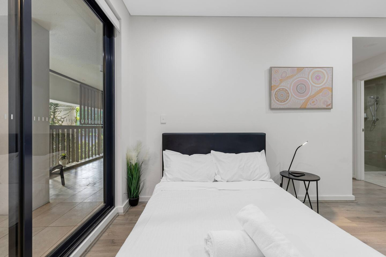 Cozy bedroom featuring balcony access and calming natural tones. By Superhostly