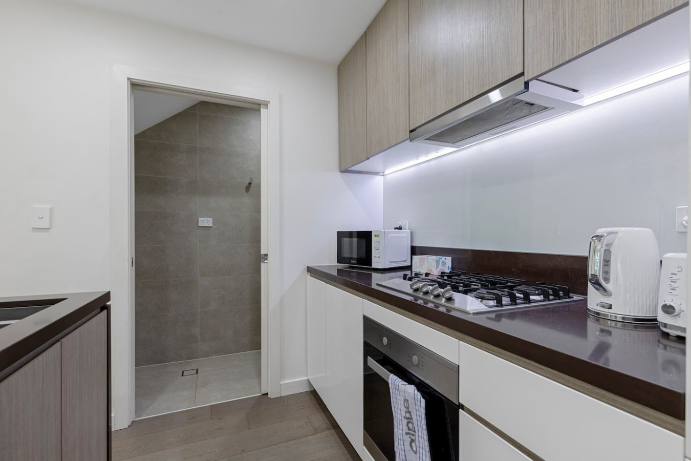Prepare meals in a clean, minimalist kitchen that maximizes space and style. By Superhostly