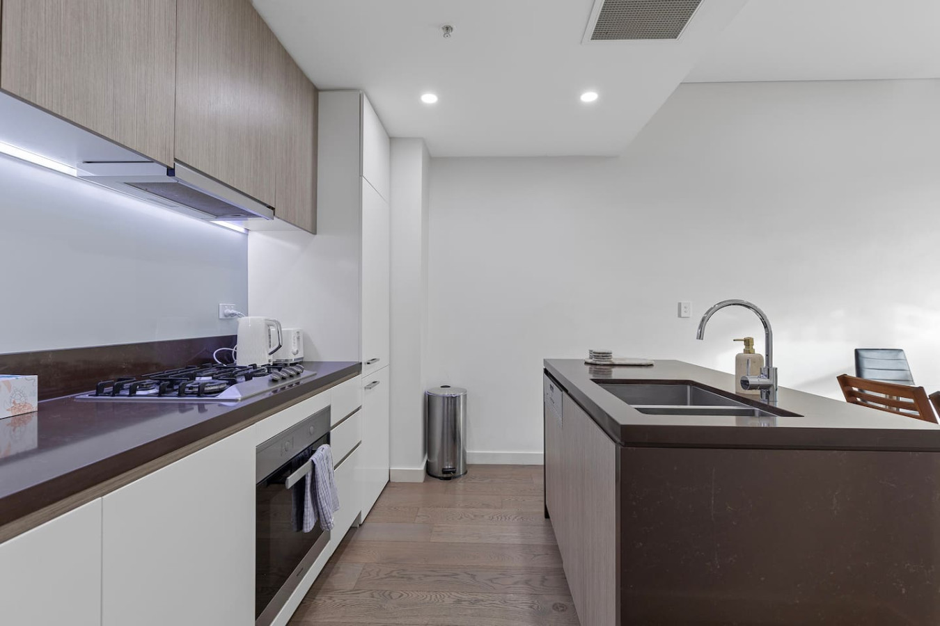A fully equipped modern kitchen with gas cooktop, ideal for home-cooked meals. - By Superhostly