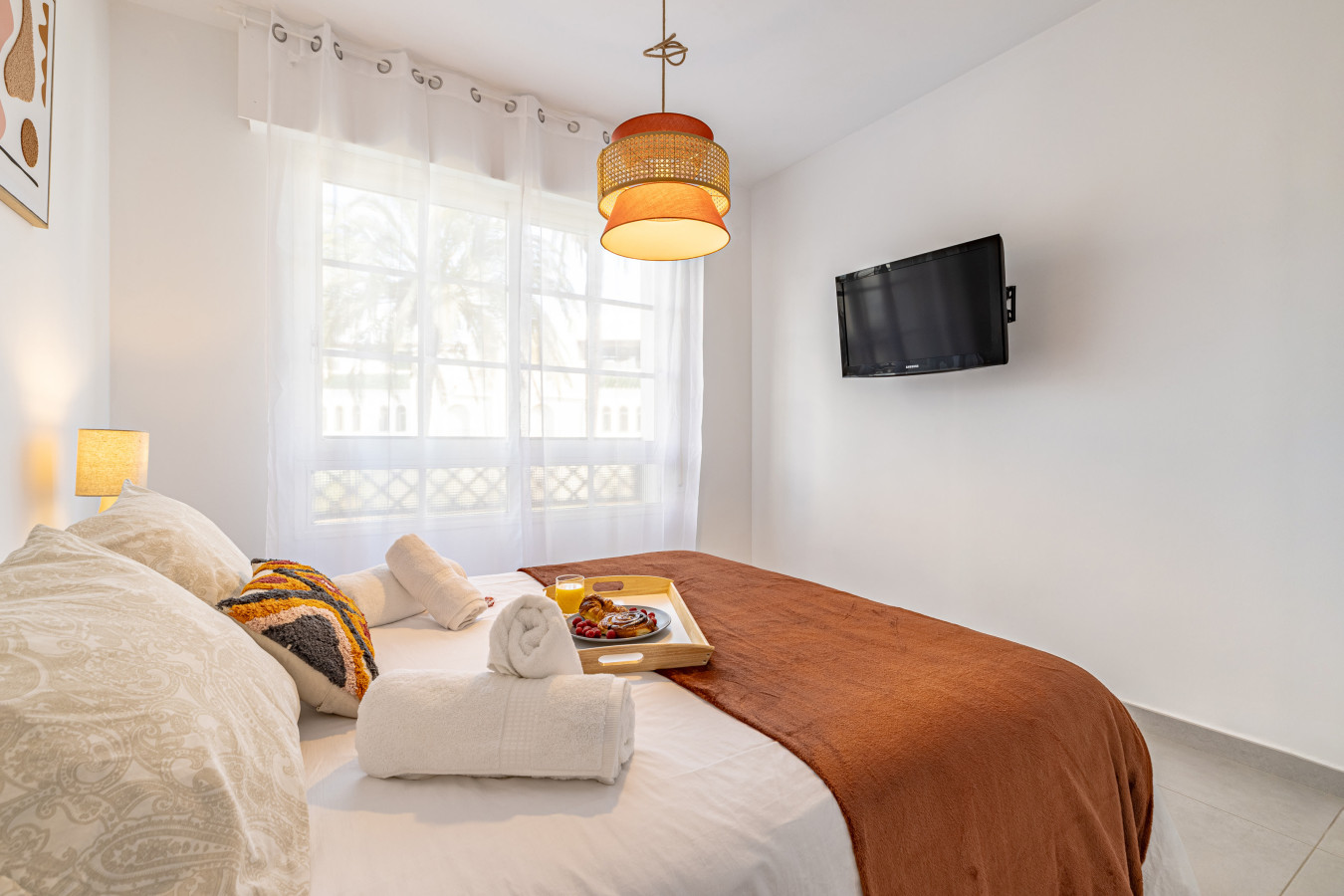Second bedroom with double bed, TV, and pool views