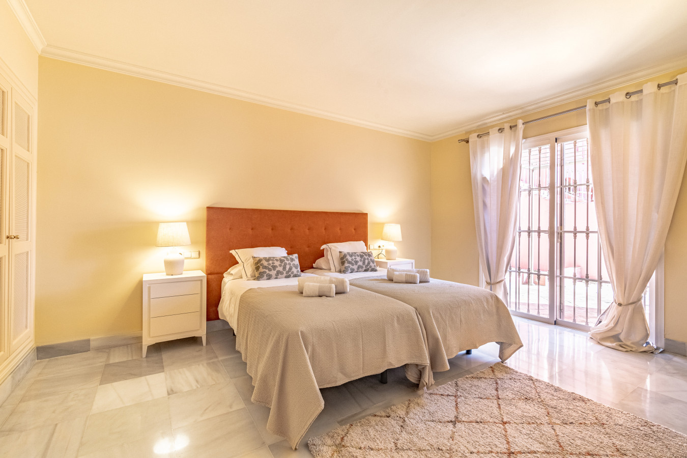 Master bedroom with twin beds, en-suite bathroom, and private terrace