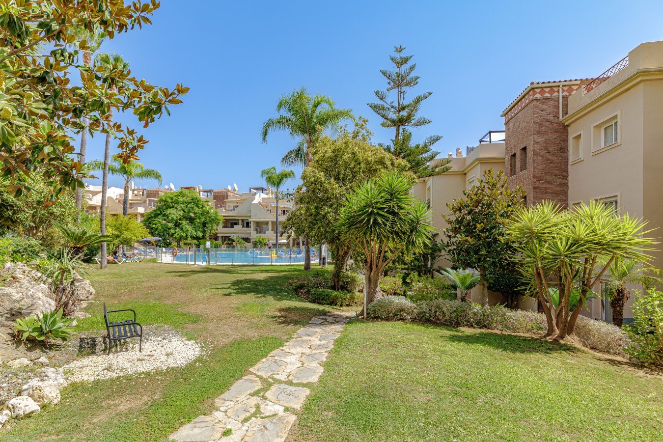 Landscaped communal gardens with the pool beyond