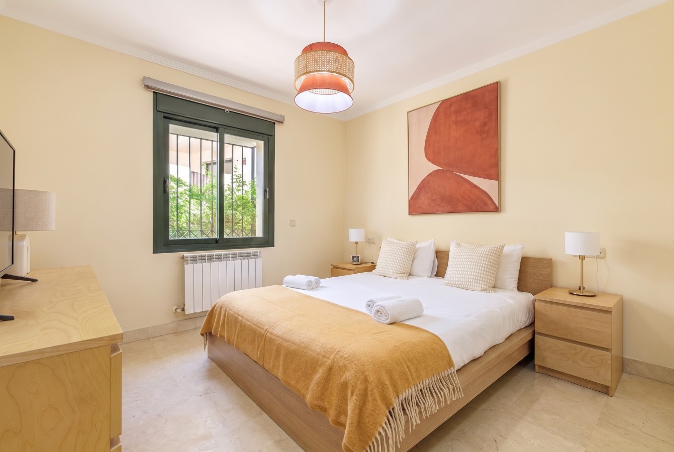 Master bedroom with double bed, TV, and garden views