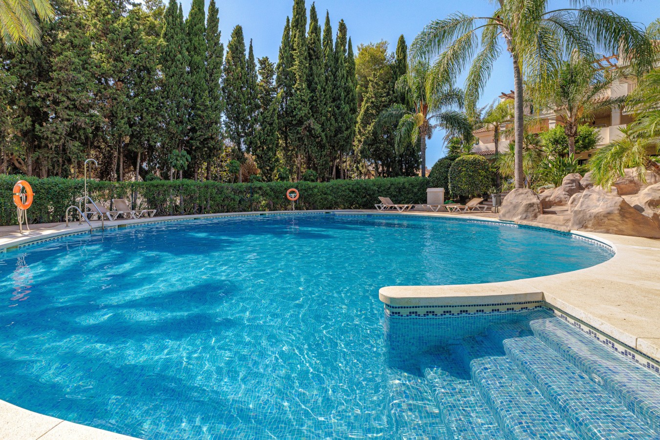 Sun loungers beside the communal pool