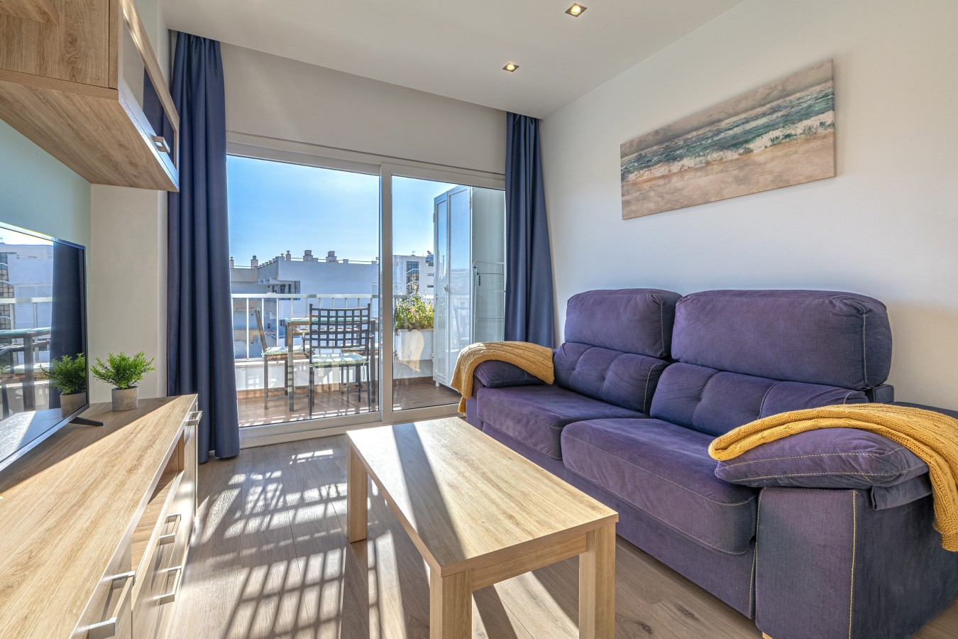 Sofa and smart TV, with the terrace doors alongside