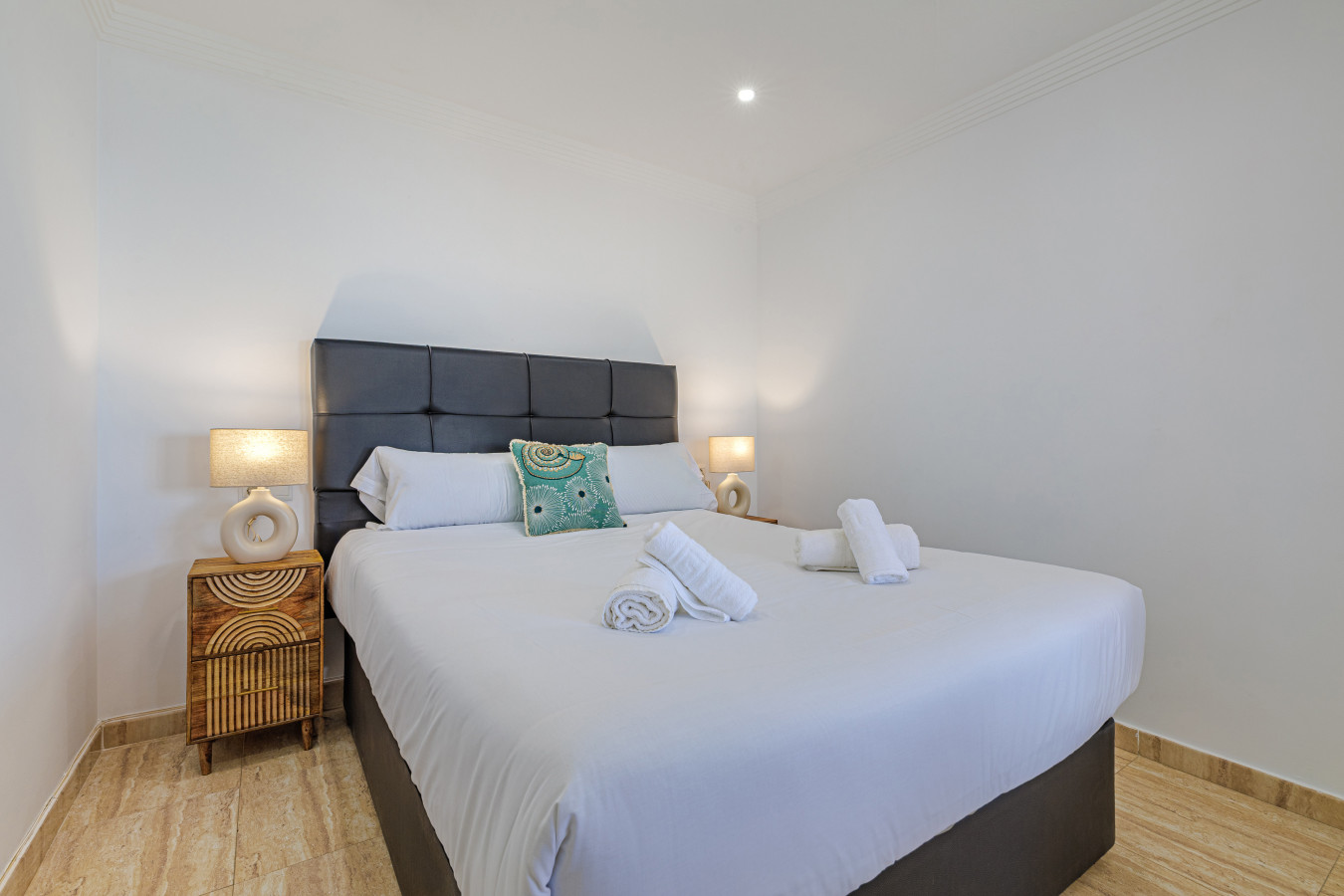 Relax in this tranquil Marbella bedroom, featuring hotel-quality linens and a cozy atmosphere to recharge after a day at the beach.