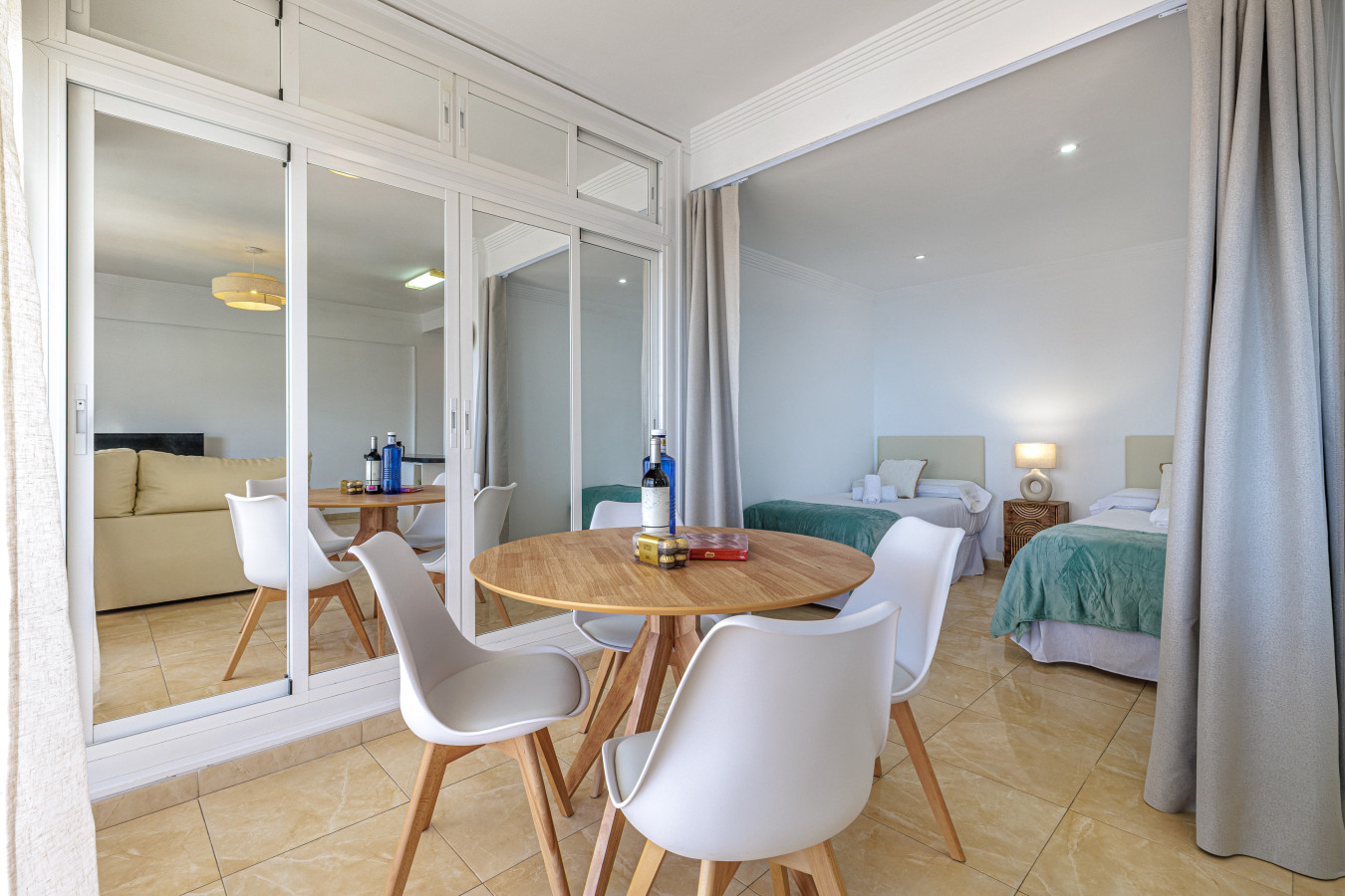 Elegant dining area flooded with natural light, featuring a seamless flow into the cozy sleeping quarters.