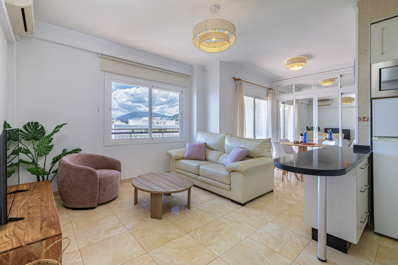 Bright, open-concept living area featuring stunning sea views, comfortable seating, and a modern kitchen space.