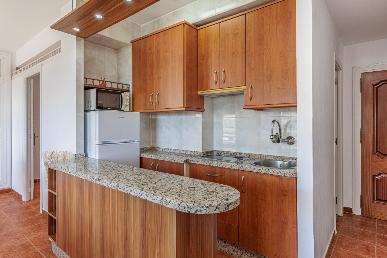 Cook local meals in this full kitchen with ample granite counter space.