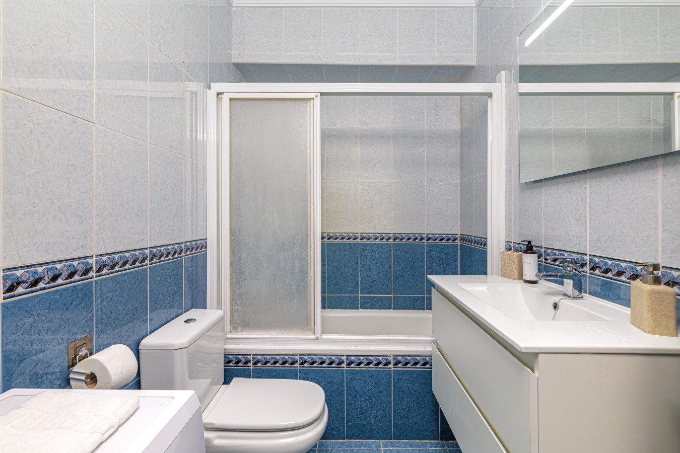 Spotlessly clean bathroom featuring a full bathtub and shower.