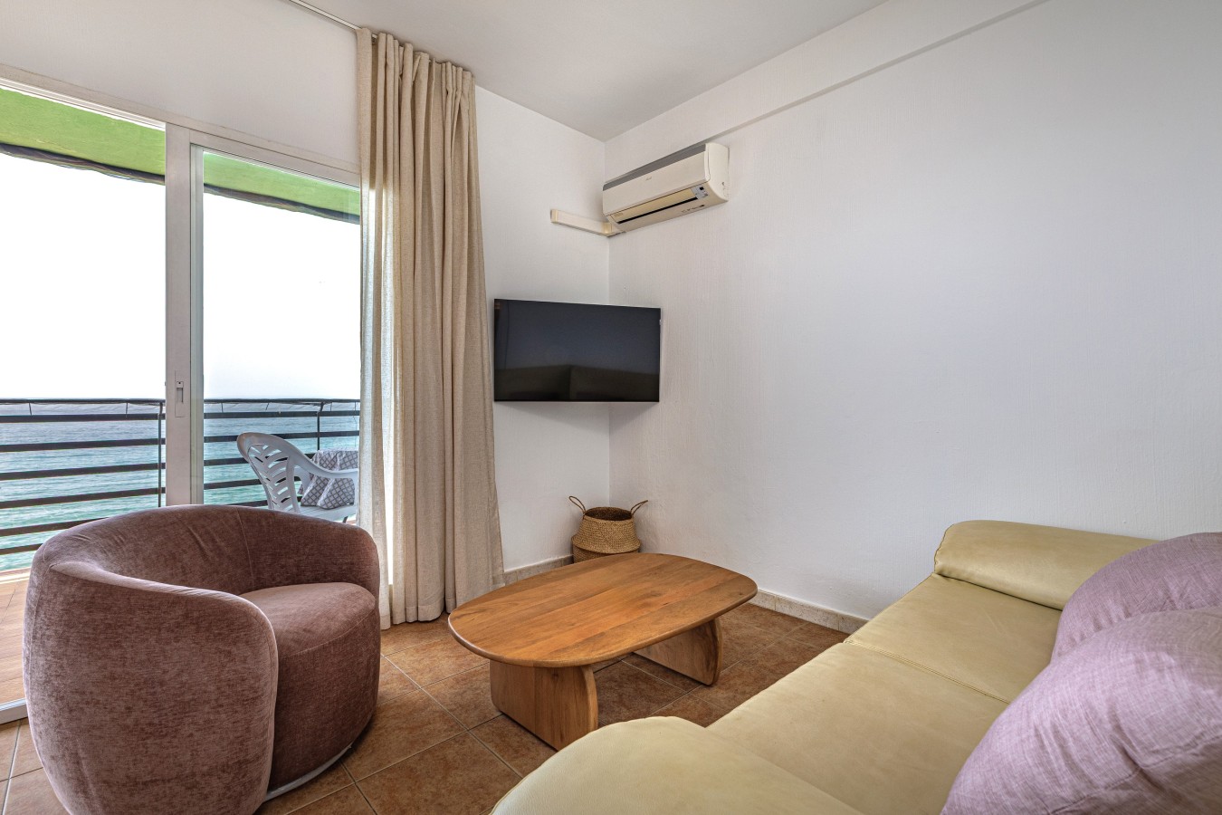 Living area with armchairs, sofa, smart TV and air conditioning