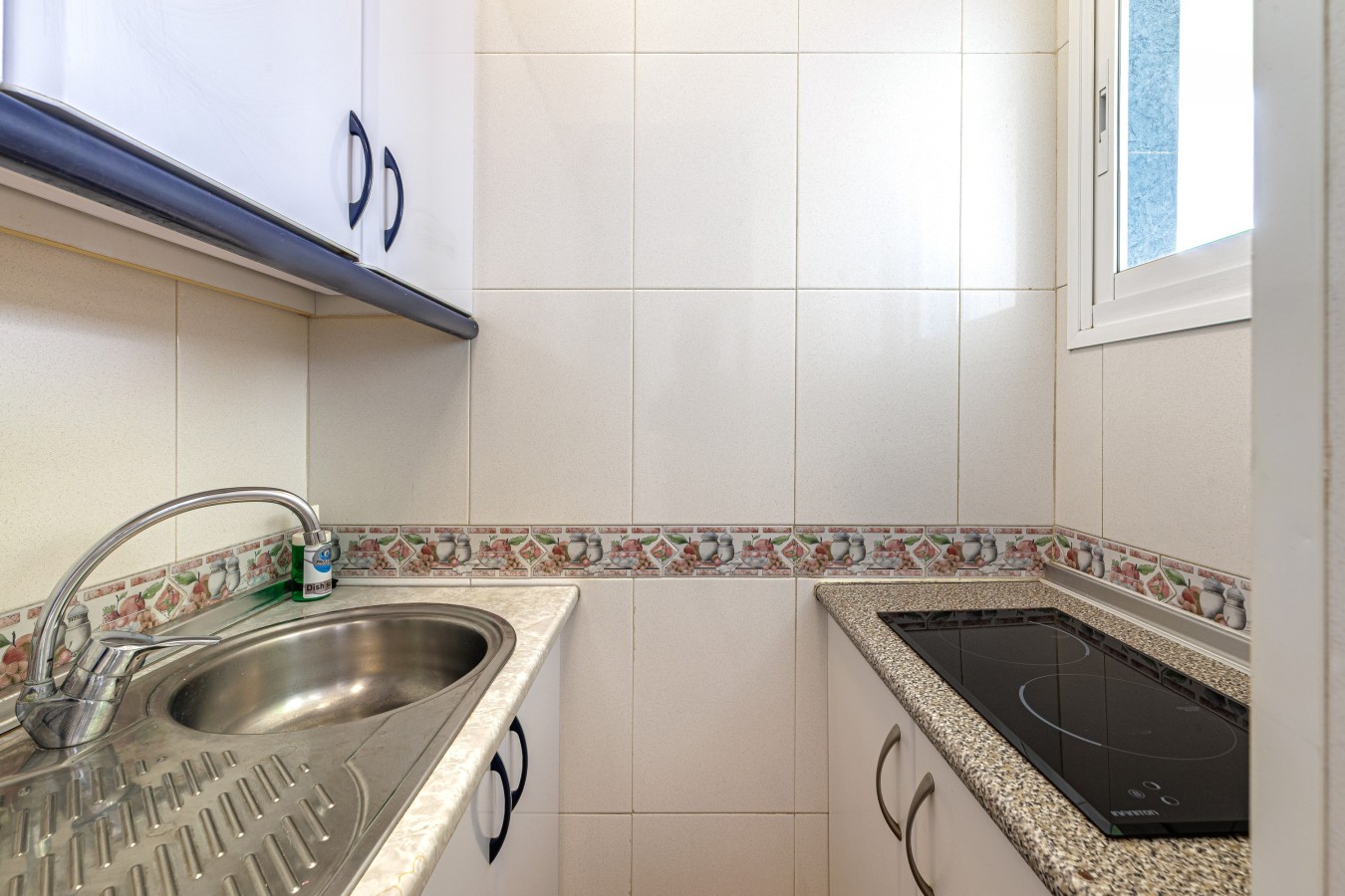 Kitchen with induction hob, granite counter and a sea-facing window