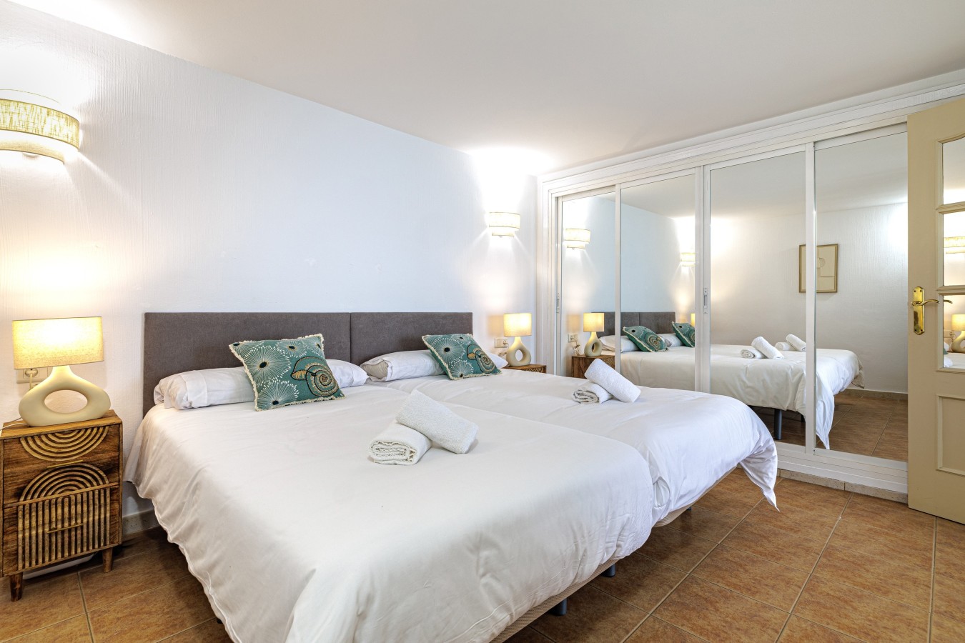 Bedroom with mirrored wardrobes and bedside lighting