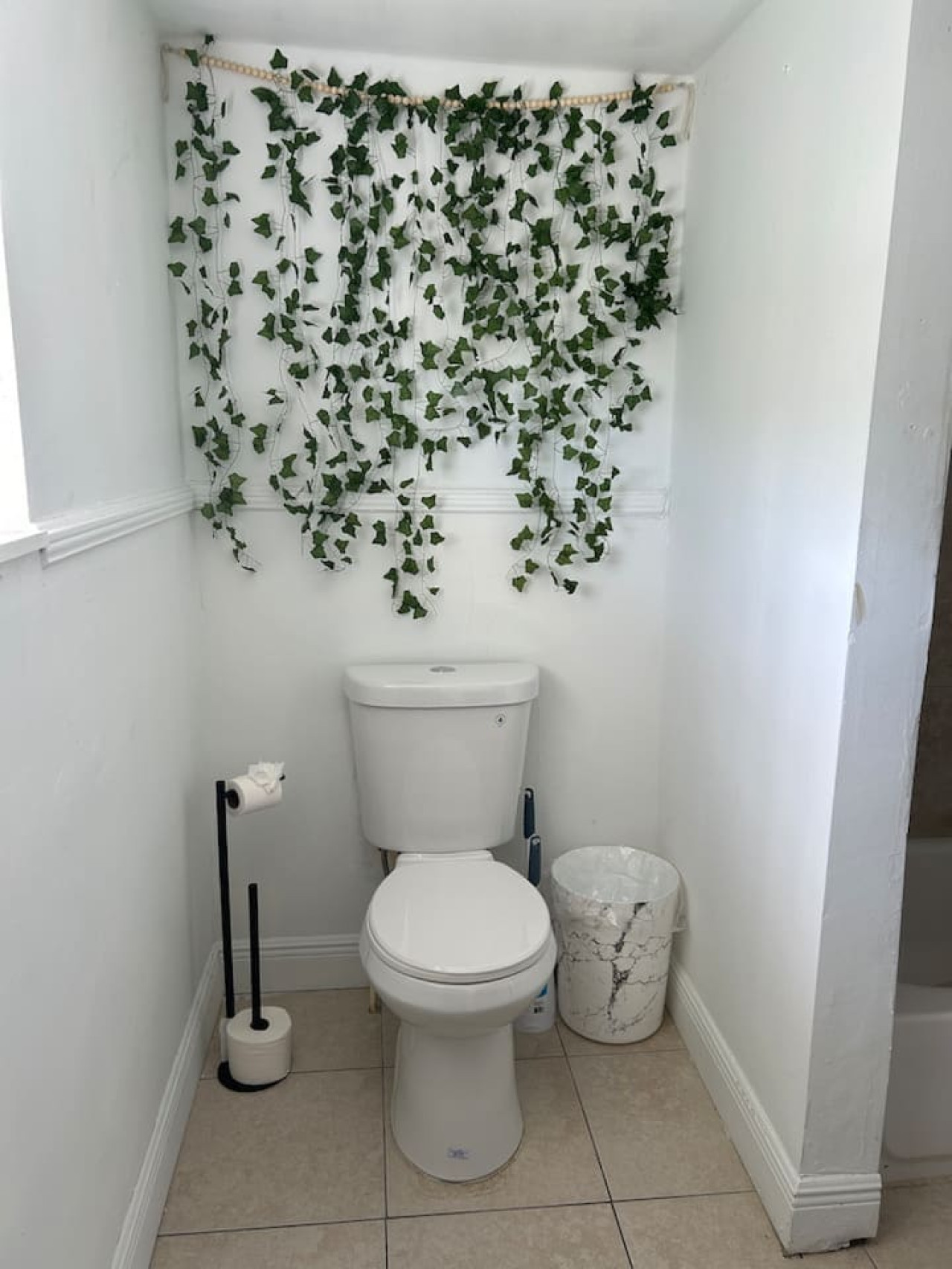 The second bathroom has its own character, including a hanging faux-ivy accent on the wall above the toilet.