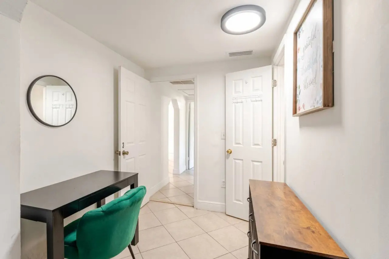 A second desk sits in the hallway nook, round mirror above it, handy if more than one person in the group needs to log on at once.