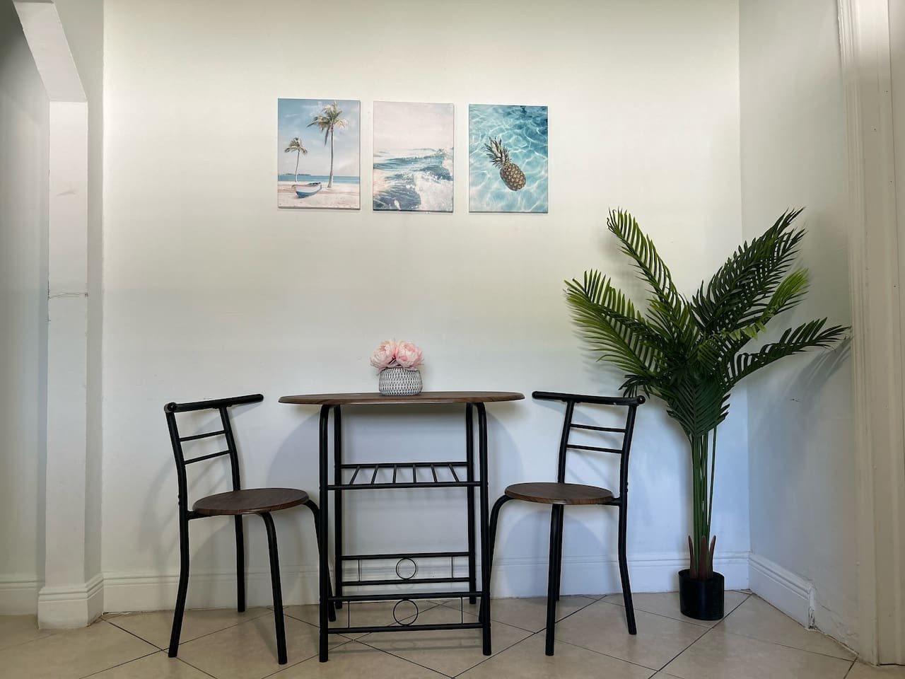 A small dining nook off the kitchen seats two, with wall art keeping the corner from feeling like an afterthought.