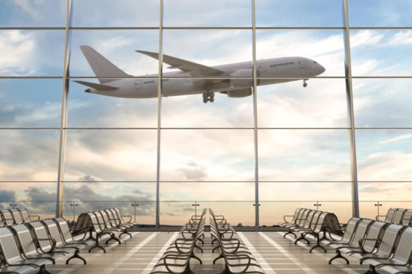 A plane comes in on approach, seen through an airport terminal window.