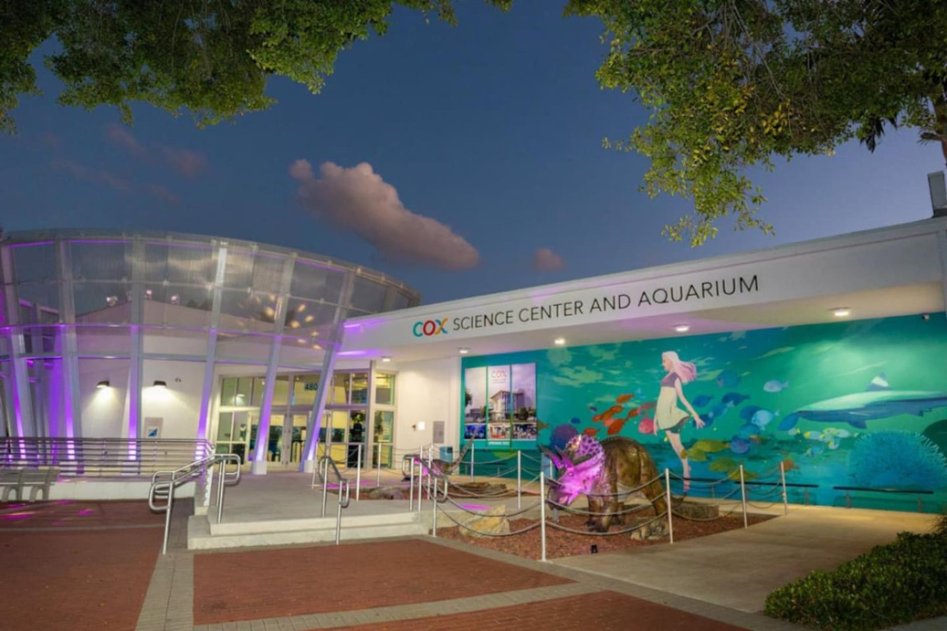 Cox Science Center and Aquarium, one of the attractions near this West Palm Beach home, lit up at dusk.