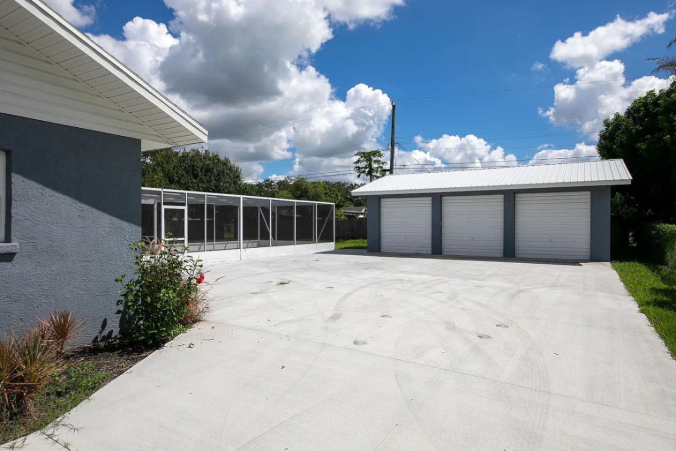 A driveway leads back toward the property's detached 3-car garage.