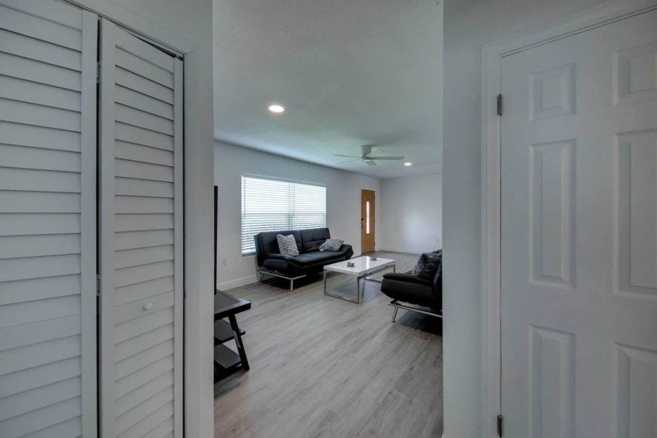 Natural light fills the same living room in this frame, with the seating arrangement visible from a different corner.