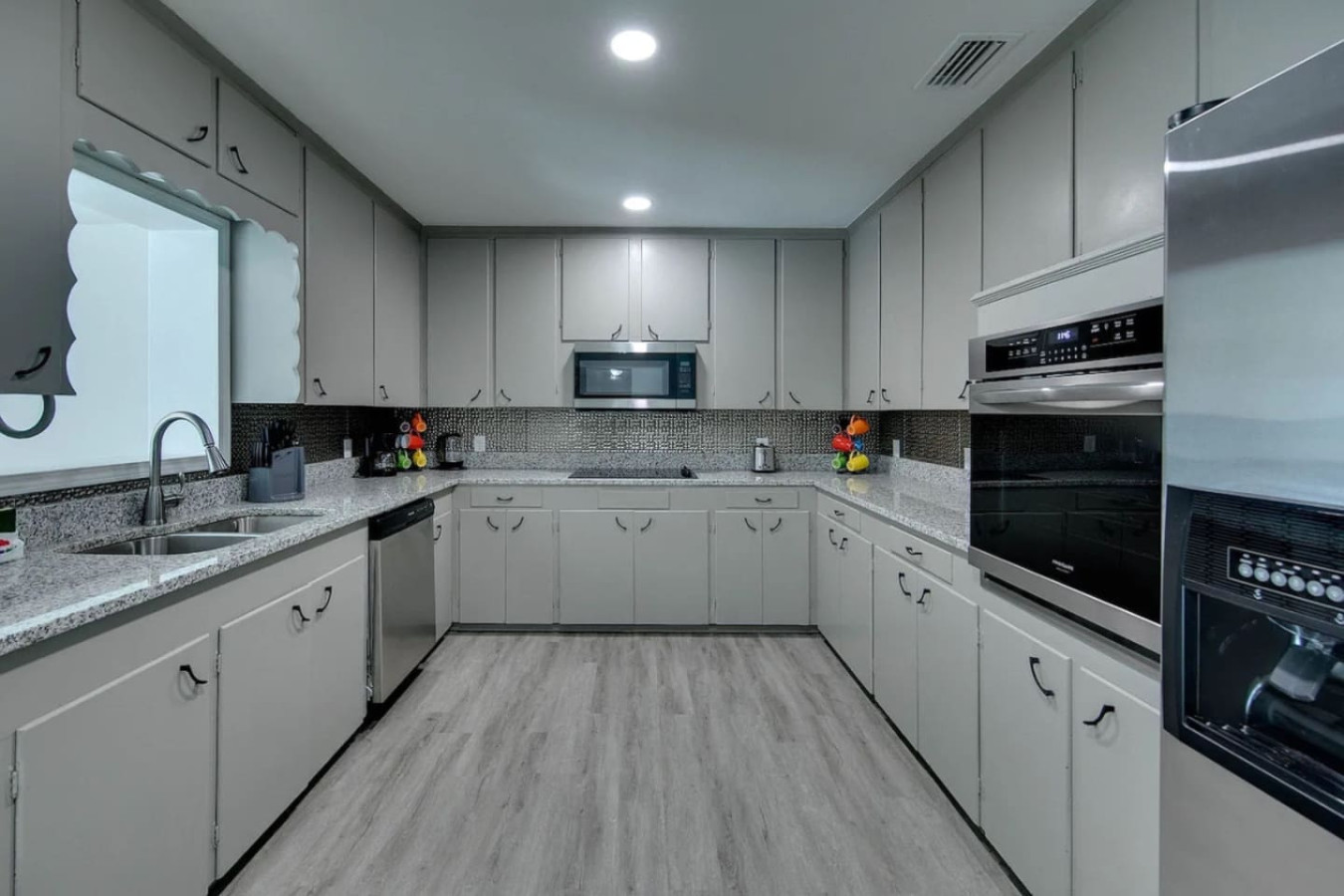 The kitchen's white-cabinet wall, with enough cookware and counter space for a full family dinner.