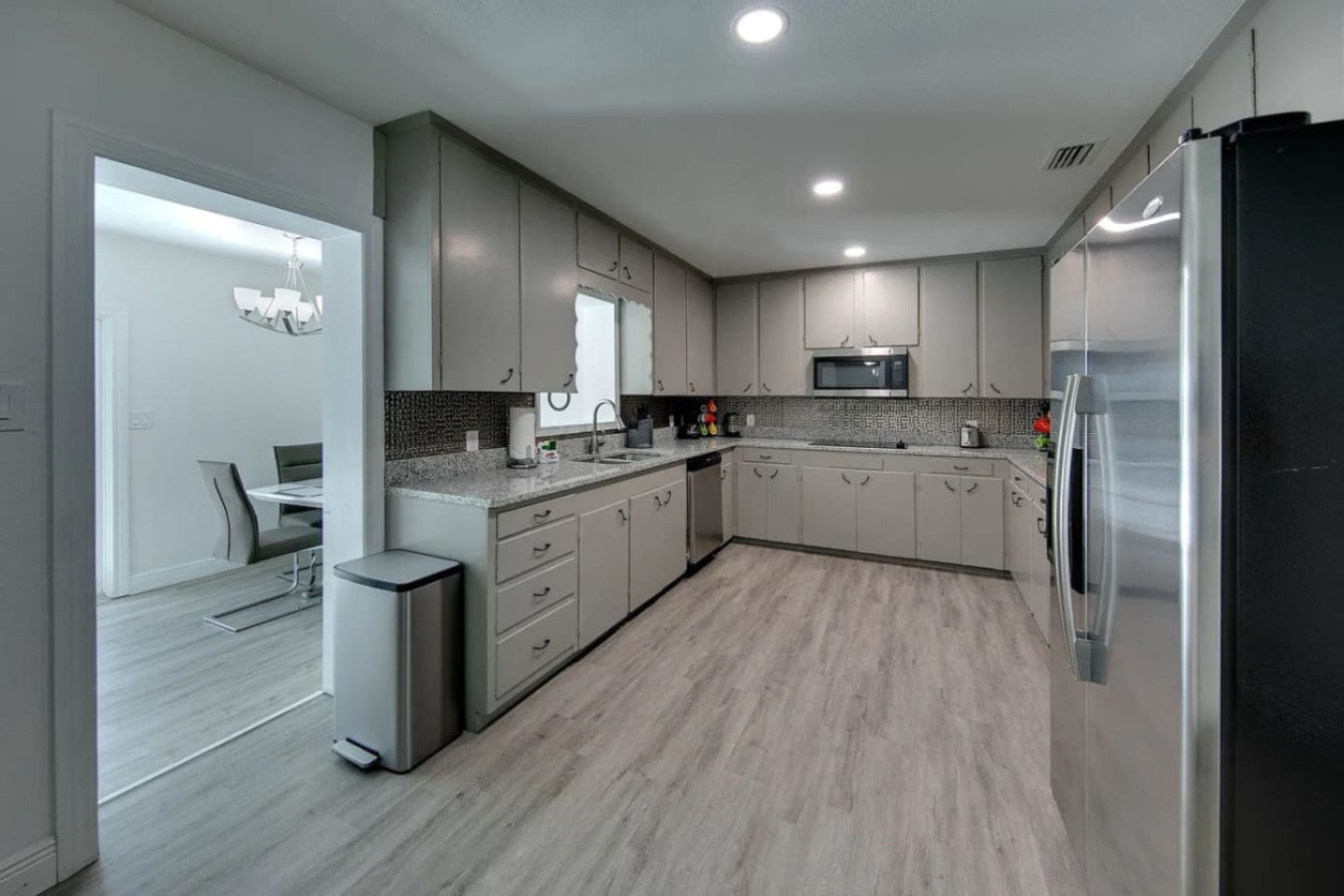 Stainless steel appliances line the kitchen, sized for cooking to feed 16 rather than two.