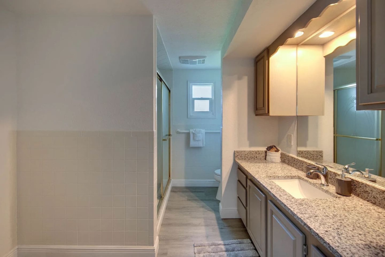 The master bathroom matches the same new tile and vanity style, attached to the king bedroom.