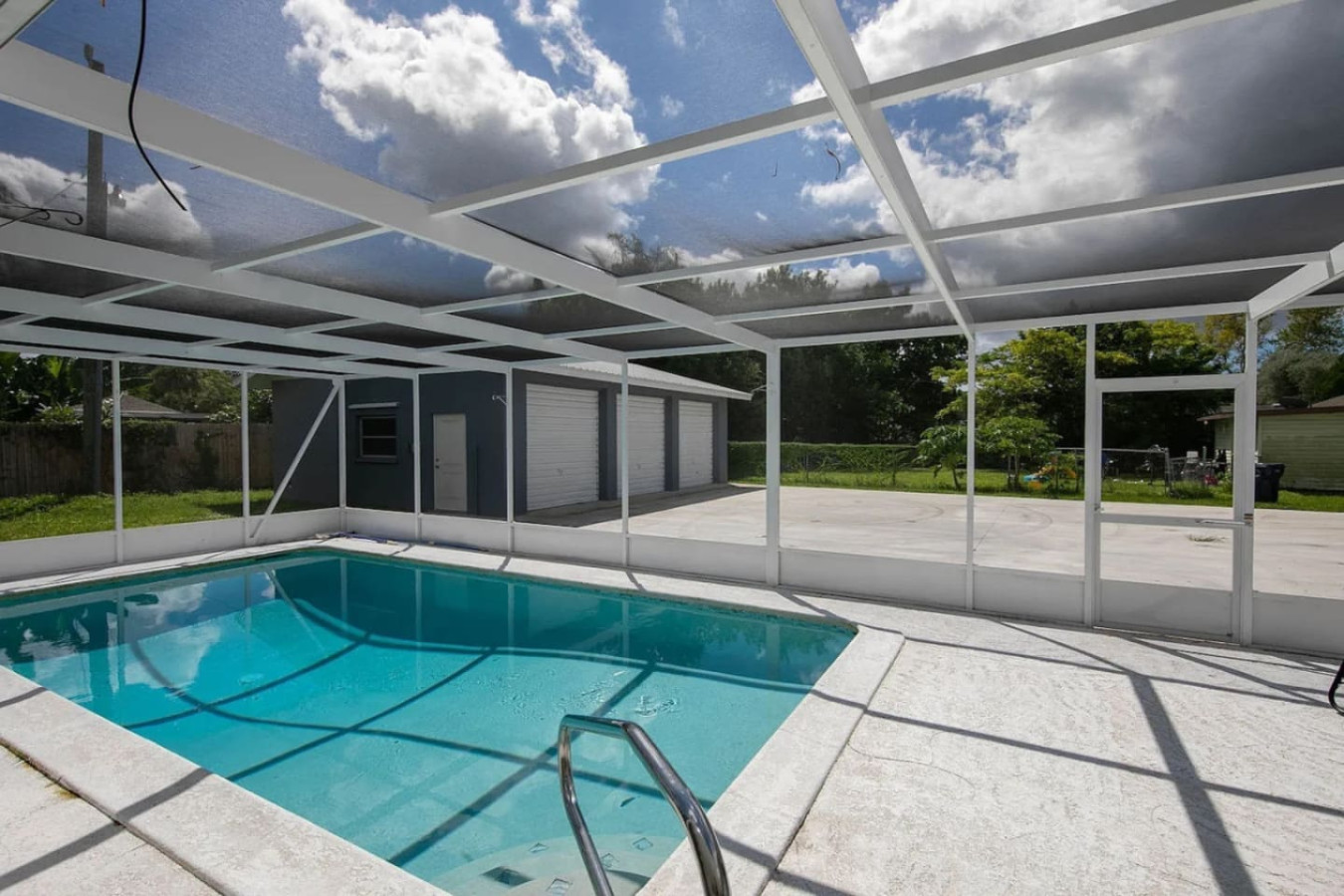 The pool enclosure again, seen from across the water toward the seating area.