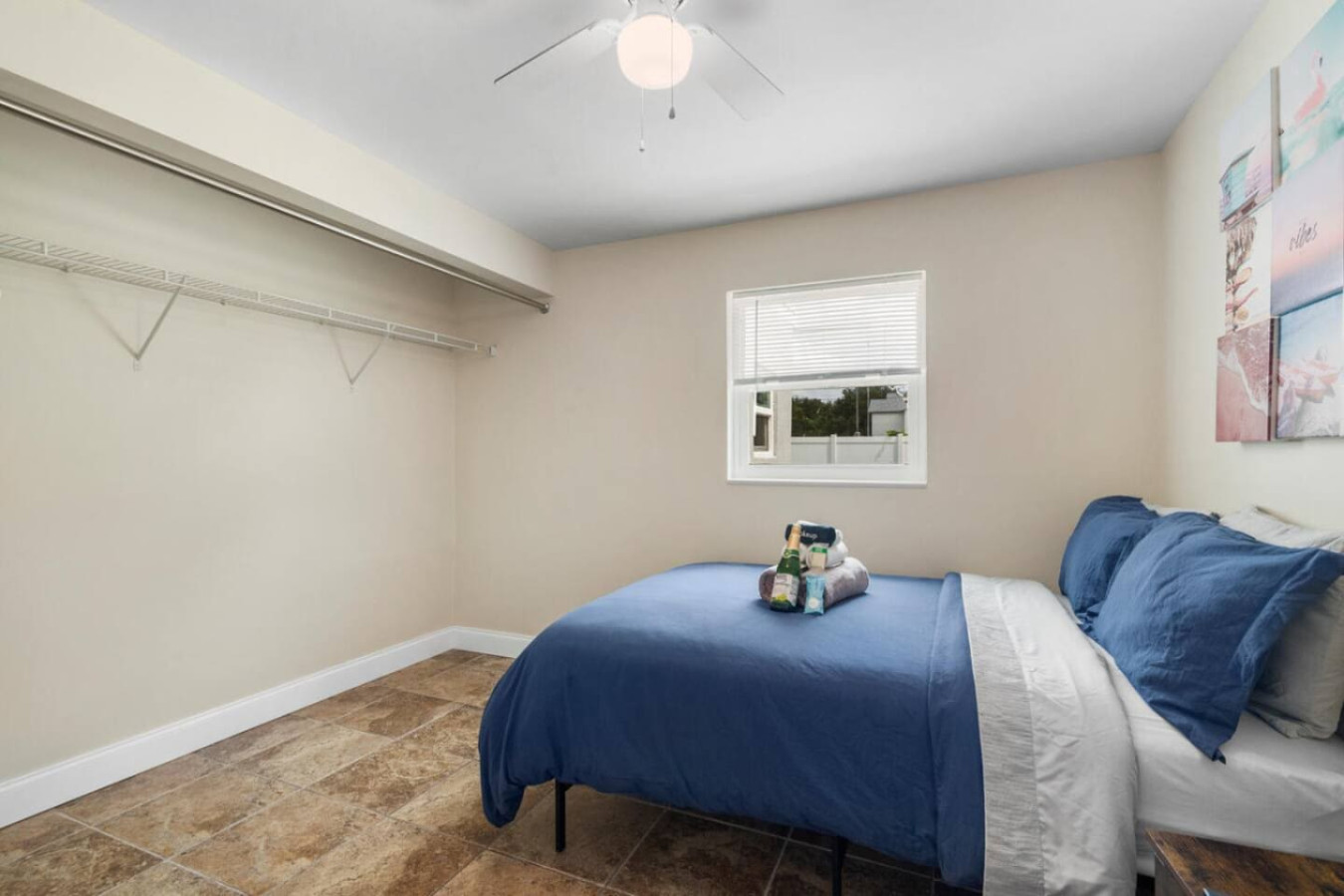 Another of the property's private bedrooms, with wall art, a full-size bed, and open closet space.