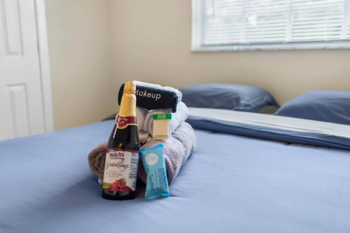 A bedroom bed set with a welcome towel set and sparkling juice, the same touch found in other rooms.