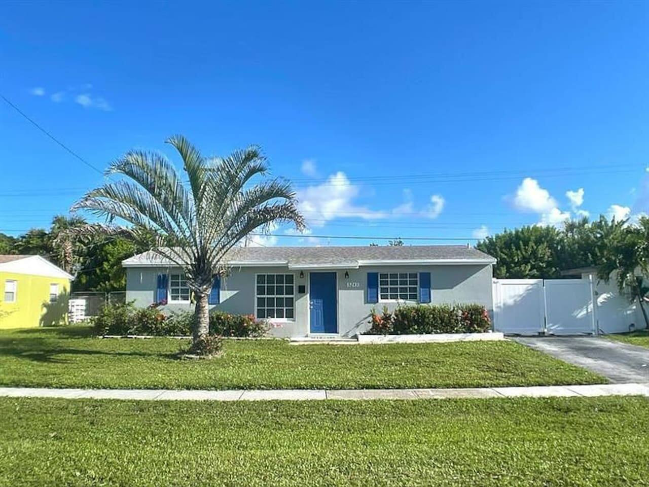 Blue trim continues along the exterior, with a gate leading back toward the private, fully fenced yard.