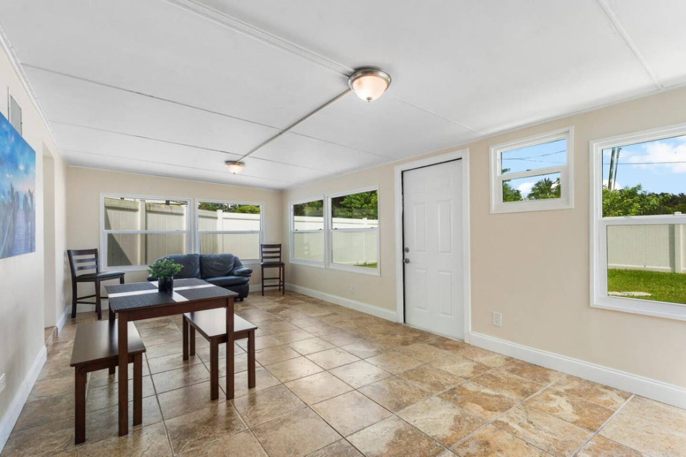 The sunroom, with bench seating around the dining table, a quieter spot for a smaller group to sit and talk away from the main living area.