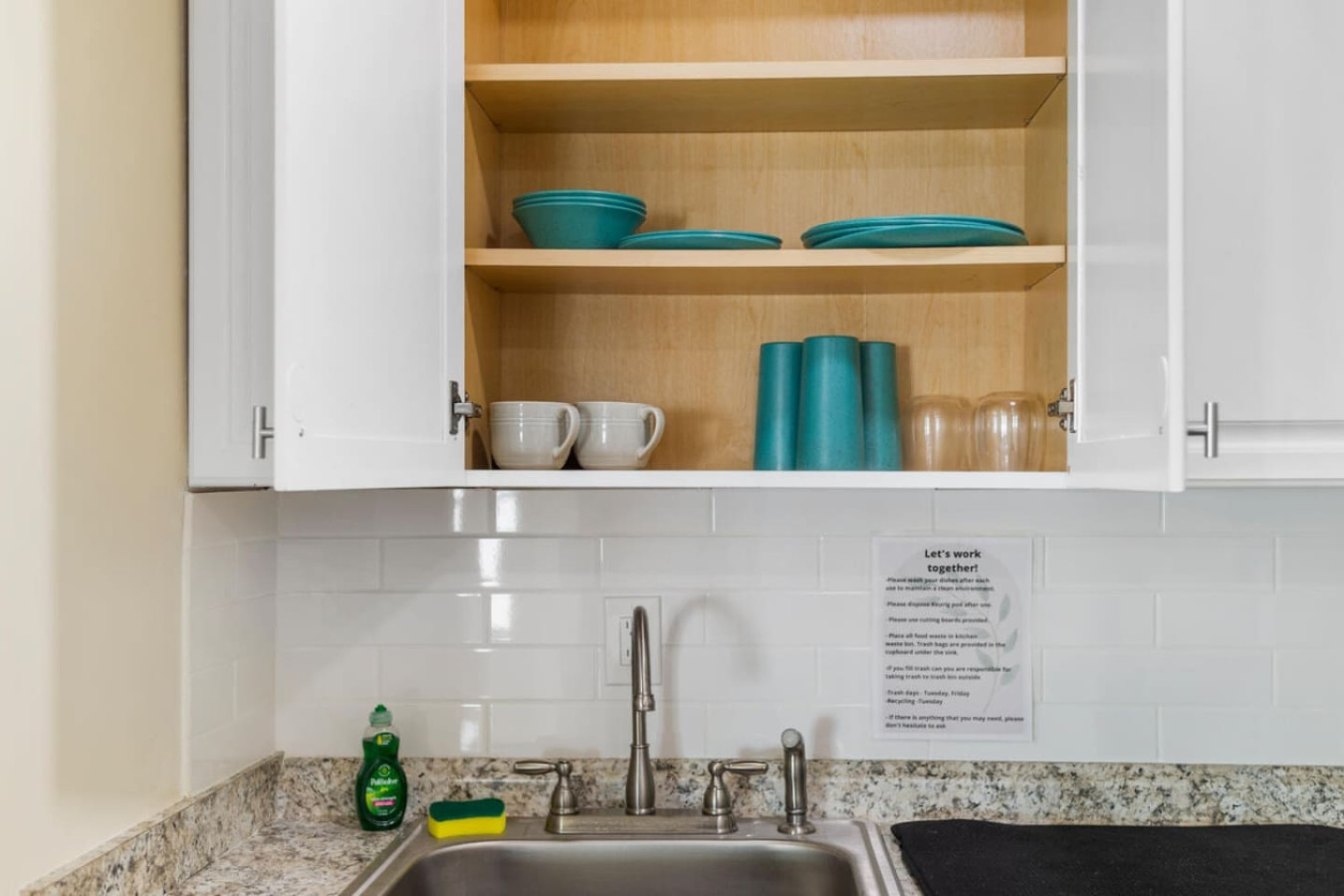 Plates, cups, and wine glasses for shared meals, set out and ready.