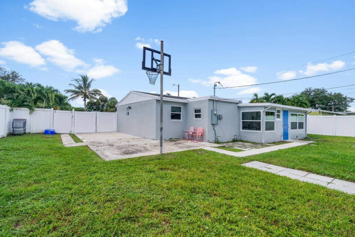 A basketball hoop in the side yard, a place for a group to step outside and move between sessions.