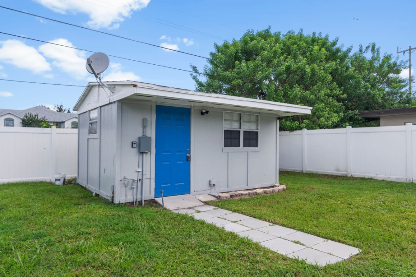 The separate guest house out back, with its own blue front door, available by request rather than included in a standard reservation.