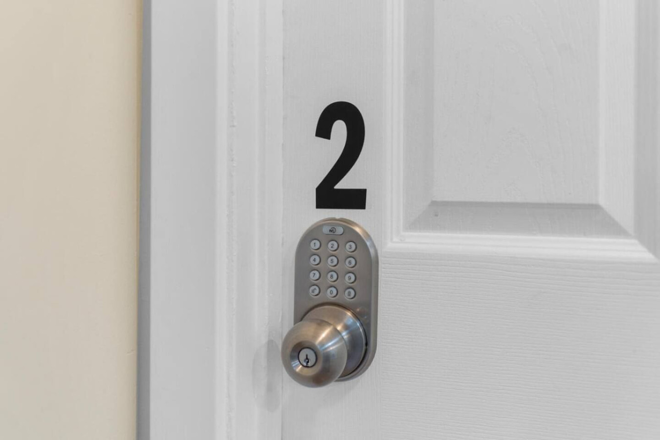 Another bedroom door, secured the same way with its own electronic keypad lock.