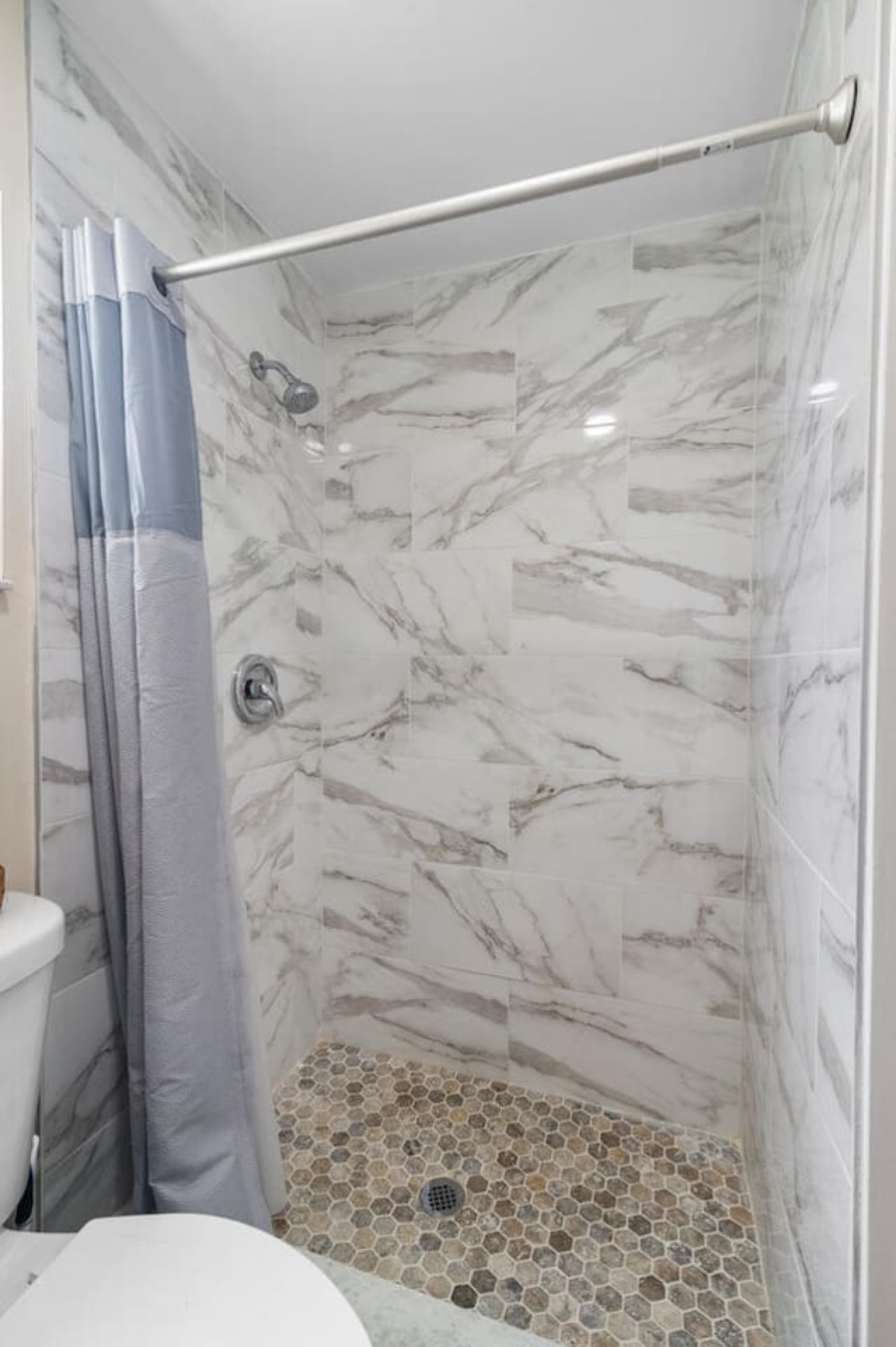 A remodeled bathroom with its own private stand-up shower.