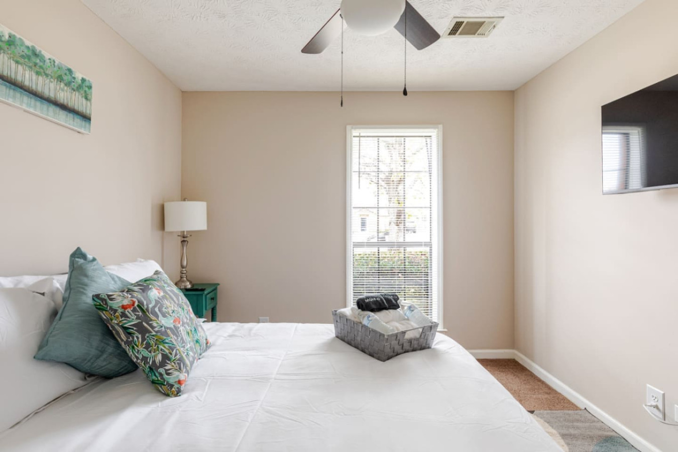 Bedroom 2 has a queen bed, a wall-mounted TV and fresh towels set out for your arrival.