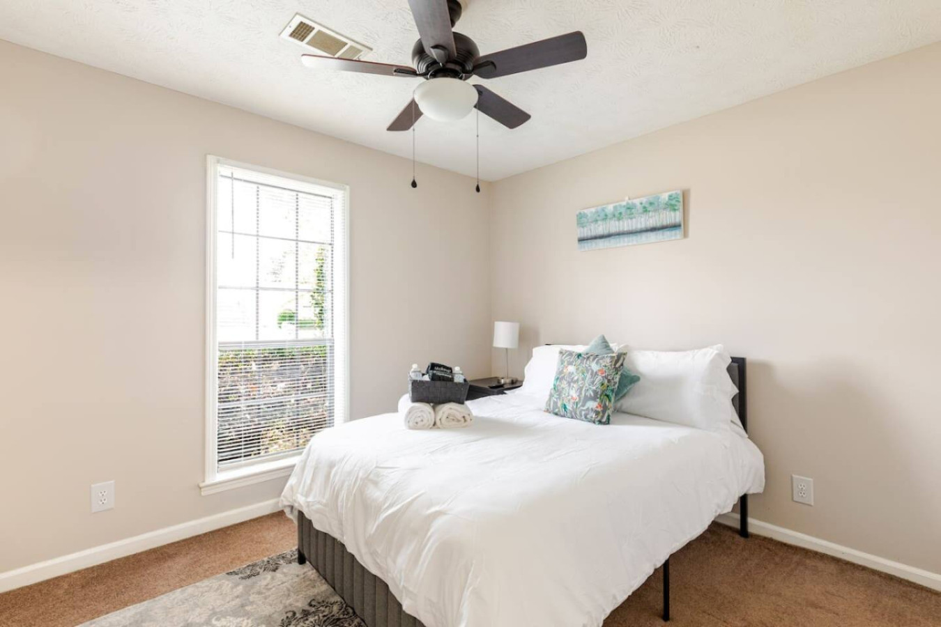 Bedroom 3's queen bed sits by the window, under a ceiling fan.