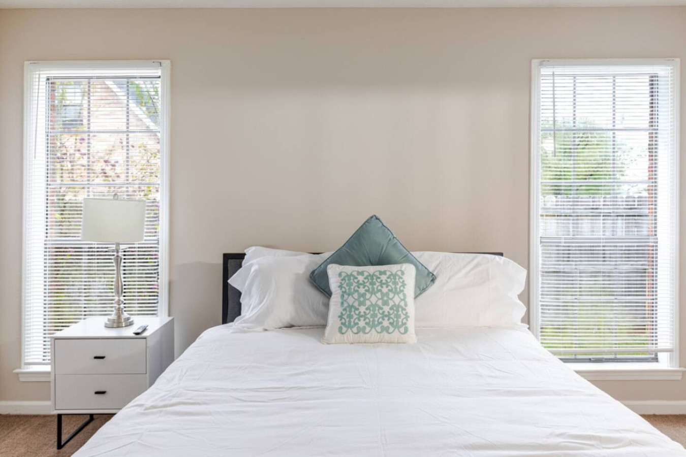Bedroom 1 is a private suite with a queen bed, windows on two sides and its own bathroom.